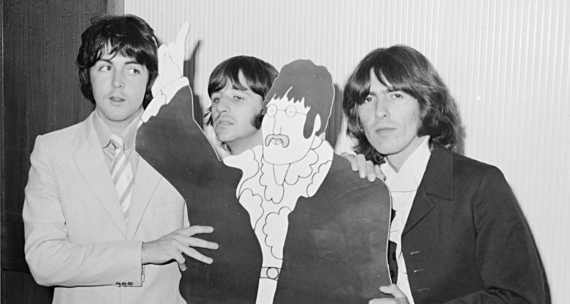 The Beatles Paul McCartney, Ringo Starr and George Harrison with a cardboard cut out of John Lennon from the film Yellow Submarine. July 1968. (Photo by Mirrorpix via Getty Images)