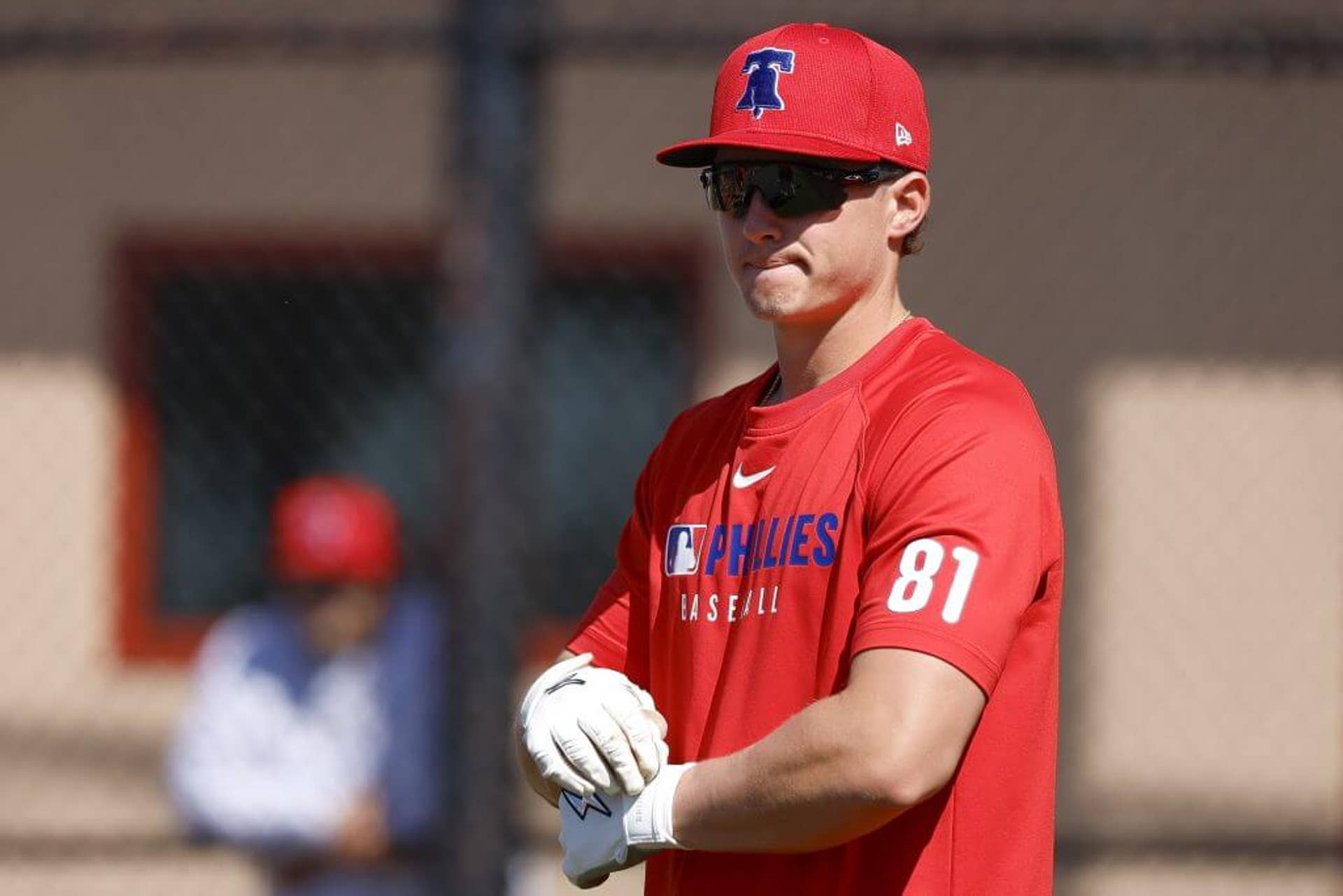 Aidan Miller of the Philadelphia Phillies adjusts the strap on his batting glove during spring training at BayCare Ballpark in Clearwater, Florida.