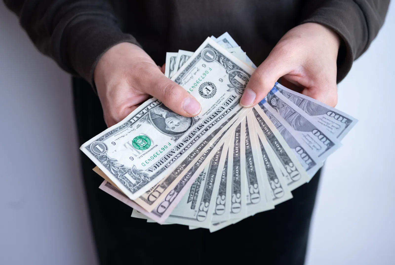 Stock image: A person is seen holding money.