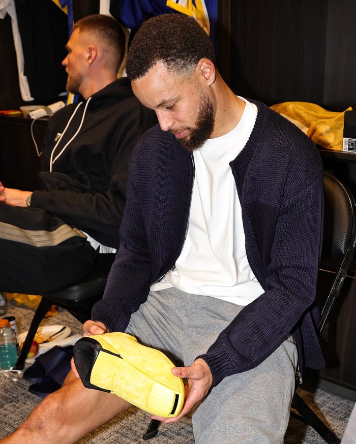 Golden State Warriors guard Stephen Curry puts on his shoes