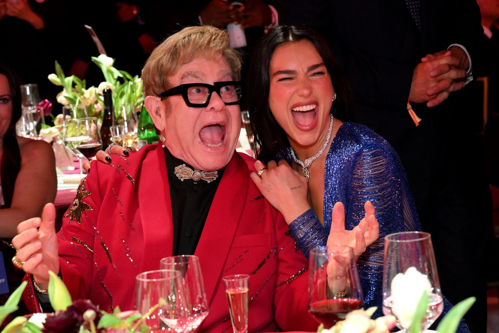 Image may contain Elton John Dua Lipa Accessories Jewelry Necklace Clothing Formal Wear Suit Glass Face and Head