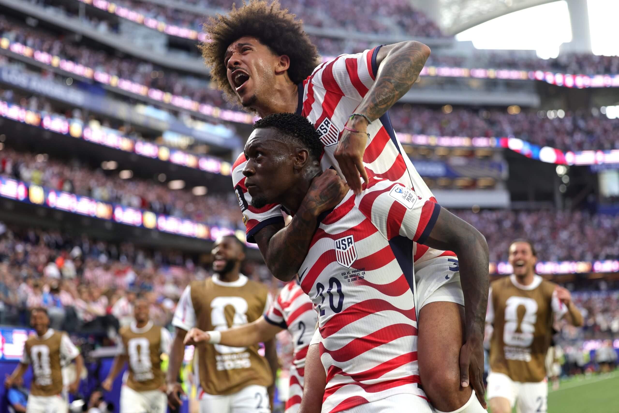 A footballer jumps on another's back