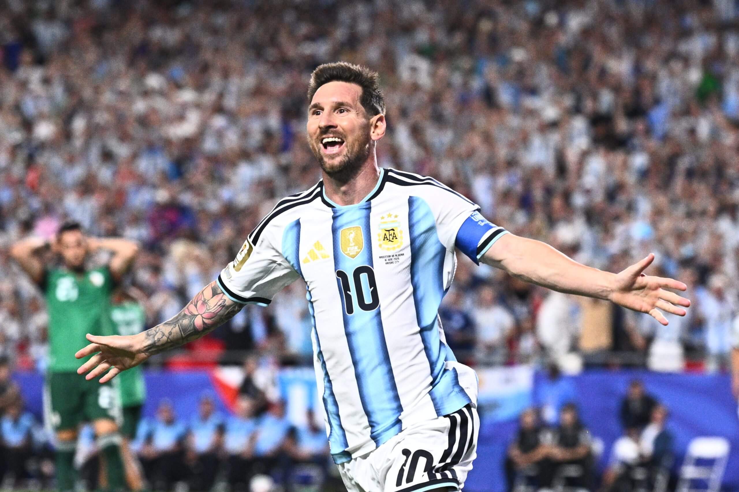 Lionel Messi celebrates with his arms out wide