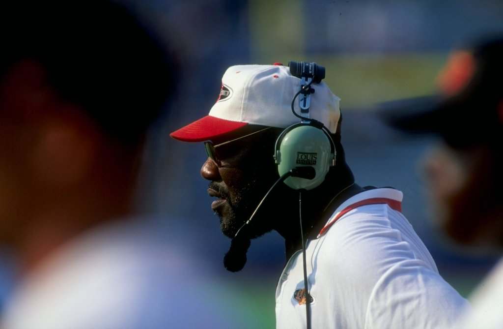 Bob Simmons wearing a headset and a white and red baseball cap.