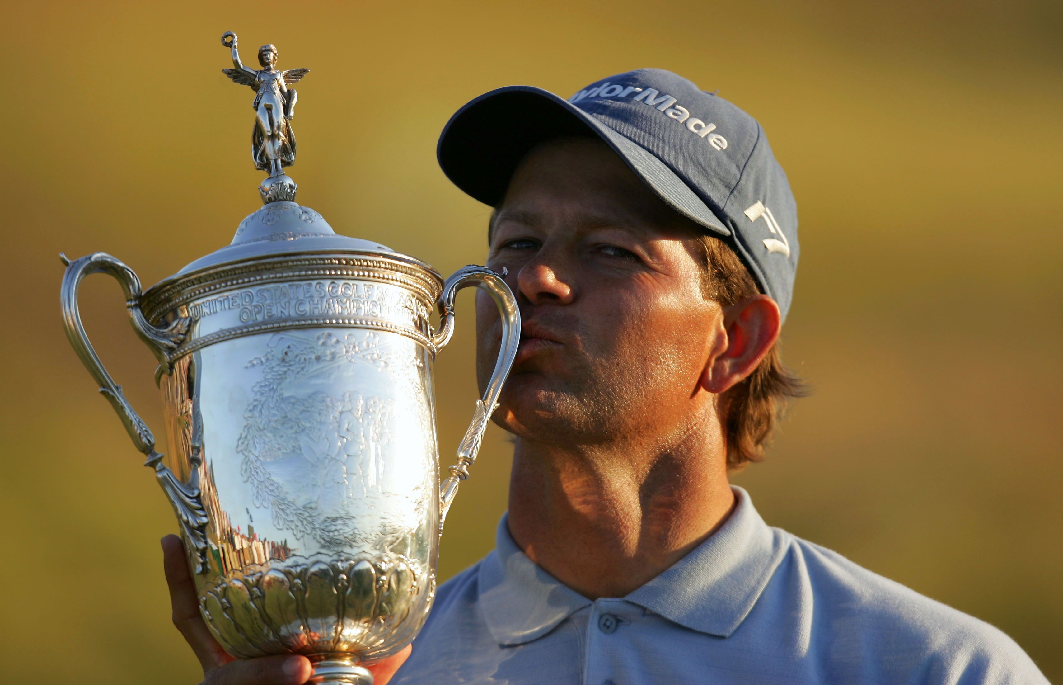 Golfer Wyndham Clark kisses the U.S. Open trophy after his victory.