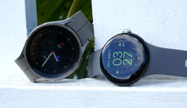 A Google Pixel Watch rests alongside a Galaxy Watch 5 pro.