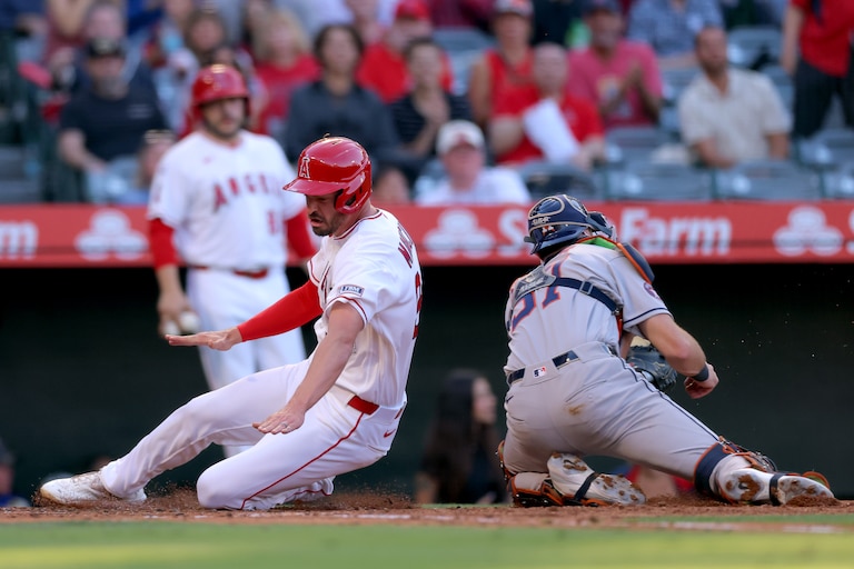 ANAHEIM, CALIFORNIA - JUNE 08: Trey Mancini #34 of the Los Angeles Angels slides into home plate to score against Collin Price #37 of the Houston Astros during the second inning at Angel Stadium of Anaheim on June 08, 2026 in Anaheim, California.