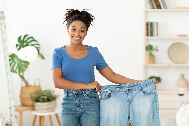 Happy Slim Black Woman Showing Old Oversize Jeans After Successful Weight Loss Diet