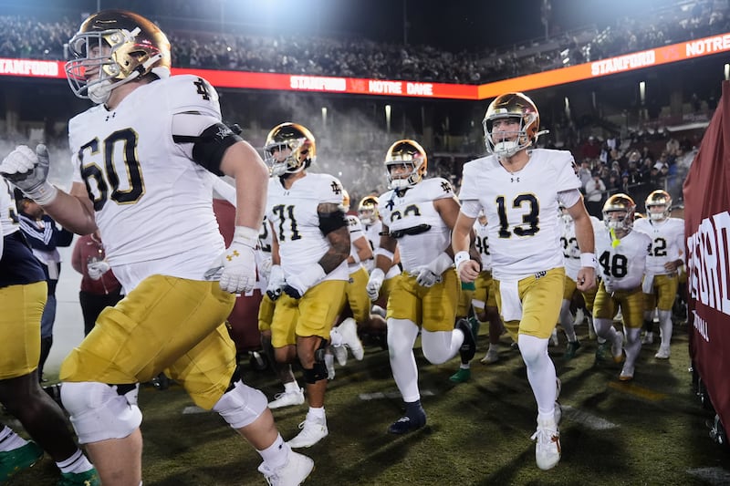 Notre Dame quarterback CJ Carr (13) and teammates take the field for a game against Stanford, Saturday, Nov. 29, 2025, in Stanford, Calif. After getting snubbed by the College Football Playoff selection committee, the Irish opted not to take the field in the Pop-Tarts Bowl, where they would have faced No. 12 BYU.