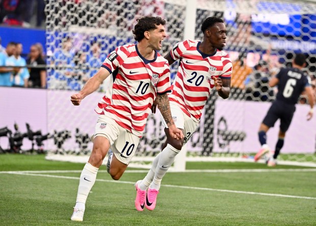 United States midfielder Christian Pulisic, left, and forward Folarin Balogun celebrate after a goal during the first half of their World Cup Group D soccer match against Paraguay on June 12. The U.S. won, 4-1, the most goals it has ever scored in a World Cup match. (Keith Birmingham - Pasadena Star-News)