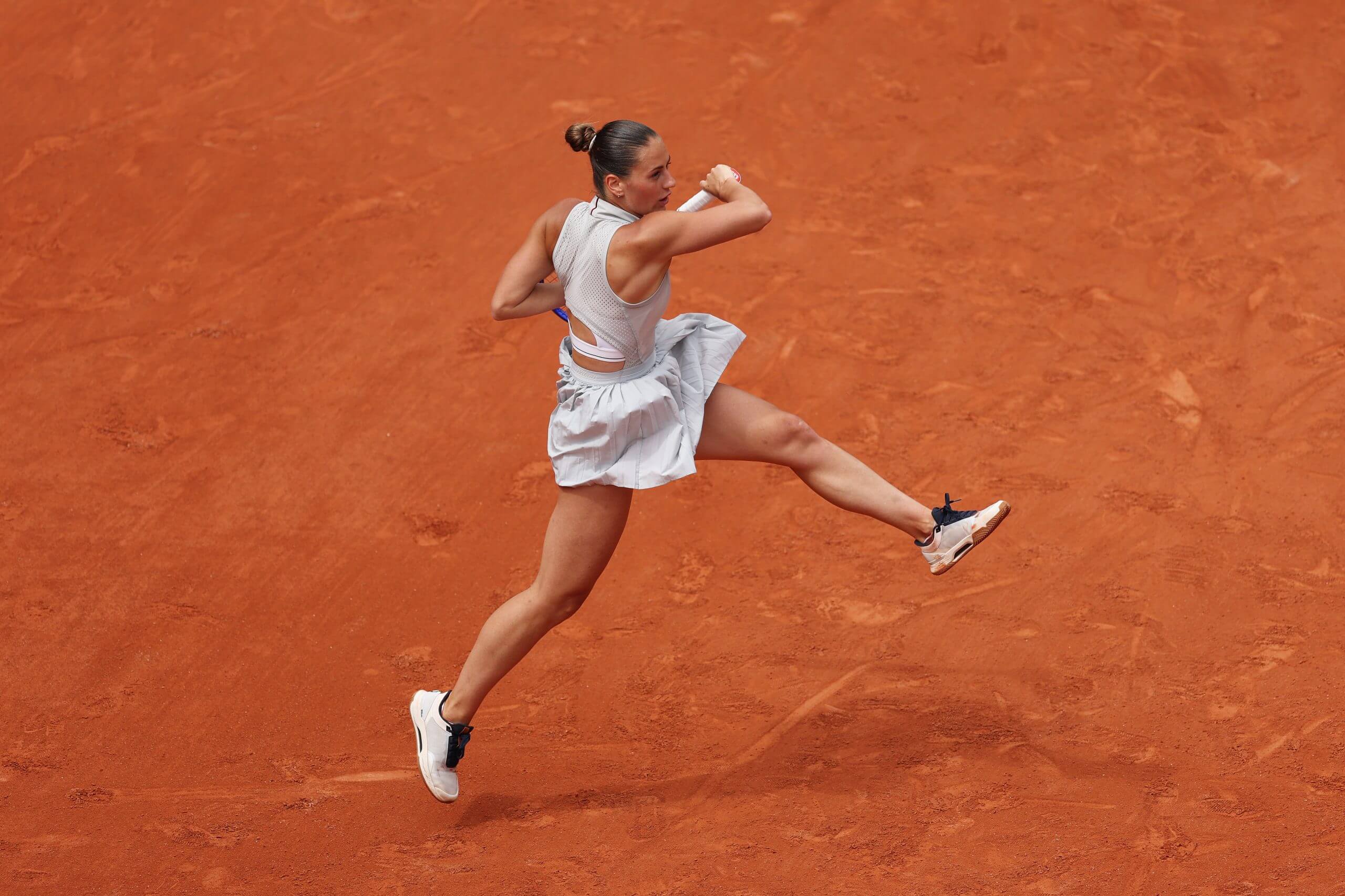 Marta Kostyuk hits a forehand on a clay court