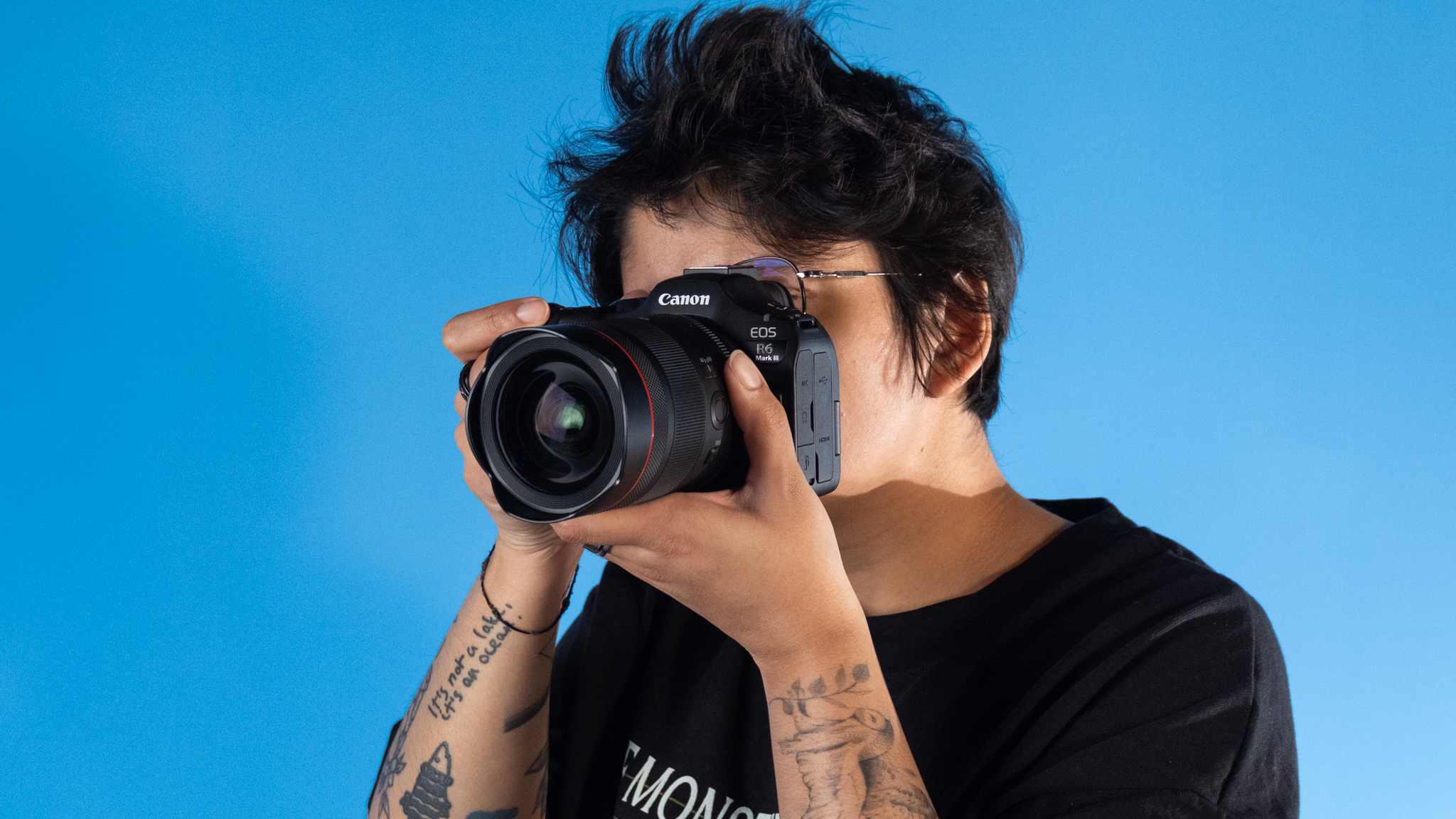 A woman holding a Canon EOS R6 Mark III