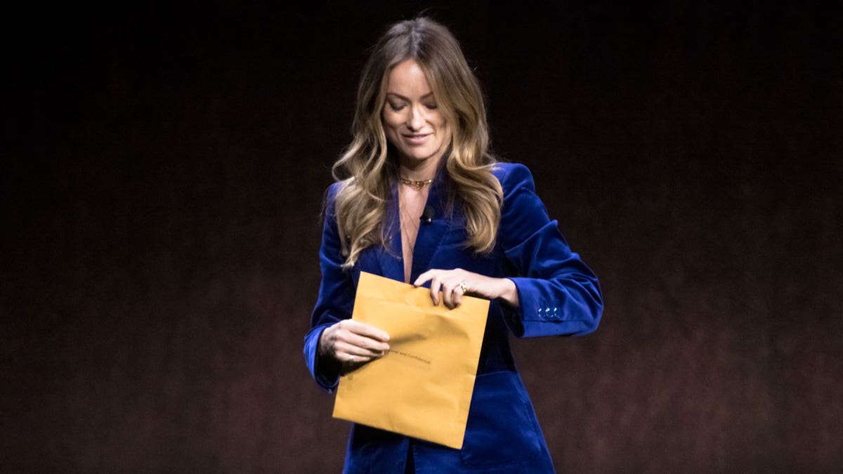 Olivia Wilde opening custody papers during a live panel at CinemaCon