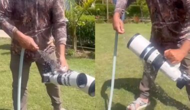 A person in outdoor clothing rinses a large camera lens with a water hose on a grassy lawn, with water splashing over the lens in both shots.