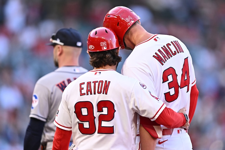Los Angeles Angels' Trey Mancini (34) is greeted by first base coach Adam Eaton (92) after hitting an RBI single during the second inning of a baseball game against the Houston Astros, Monday, June 8, 2026, in Anaheim, Calif.