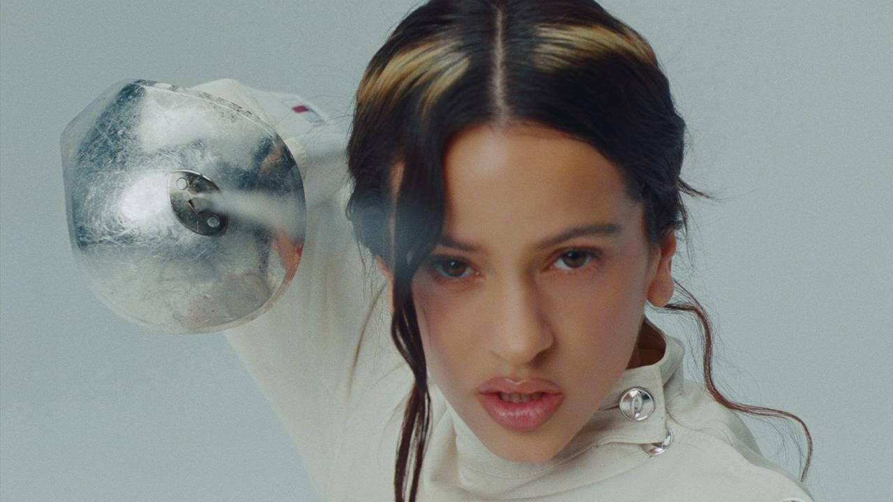 close-up photo of singer Rosalía with a halo-shaped highlight in her hair, pointing a sword into the camera