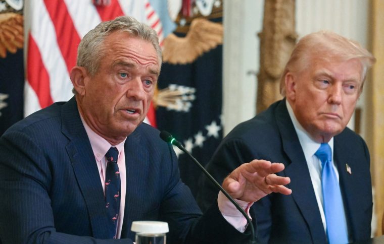 US President Donald Trump (R) listens as US Secretary of Health and Human Services Robert F. Kennedy Jr. speaks at an event on 