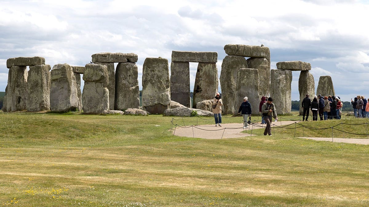 Tourists standing outside Stonehenge monument