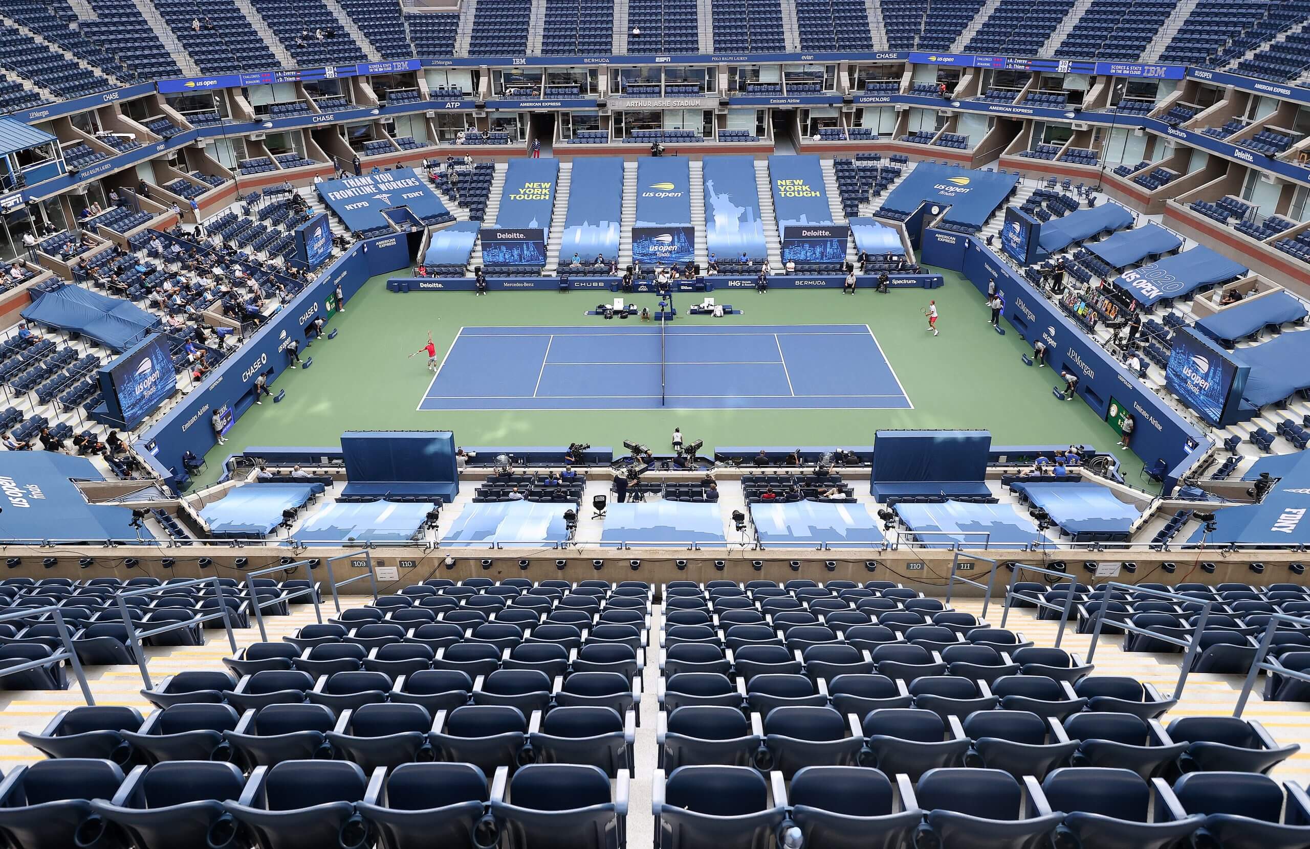 Alexander Zverev and Dominic Thiem stand on an empty U.S. Open tennis court.
