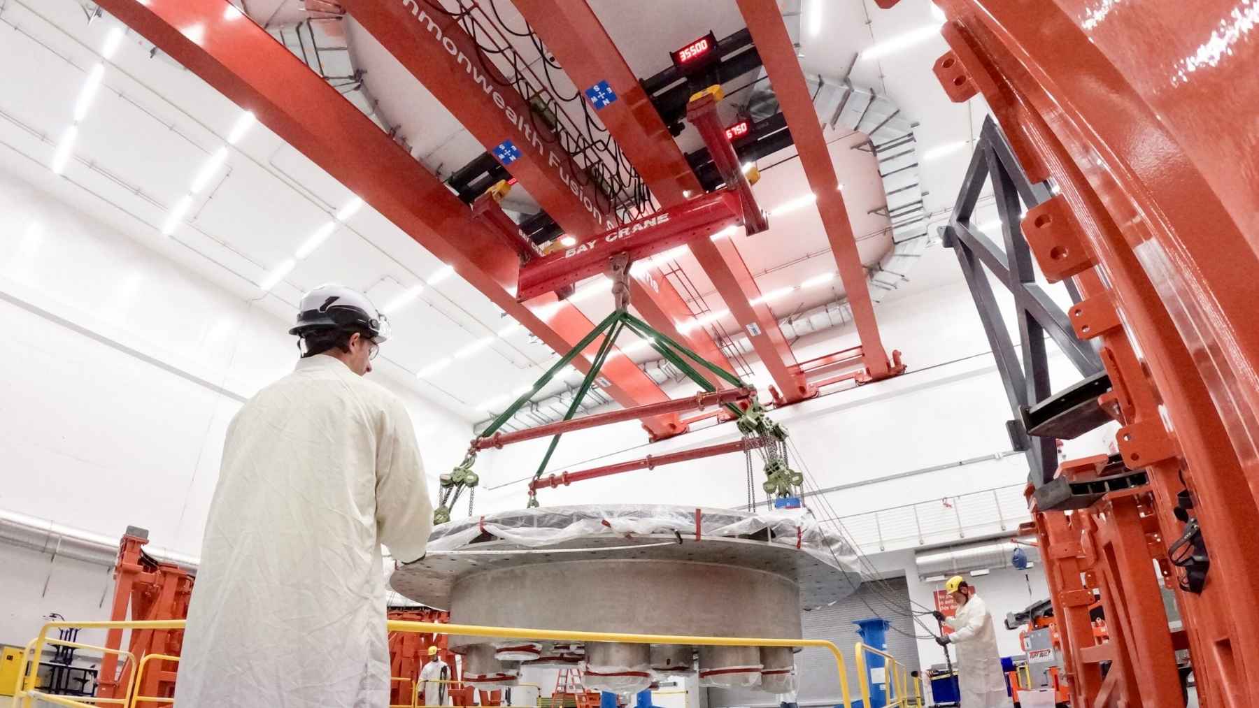 A company outside Boston just craned the second 48-ton half of a steel donut into Tokamak Hall and pushed its compact fusion reactor to 75% built, a machine chasing more energy out of fusion than it puts in by 2027, twelve years before the cathedral-sized ITER in France