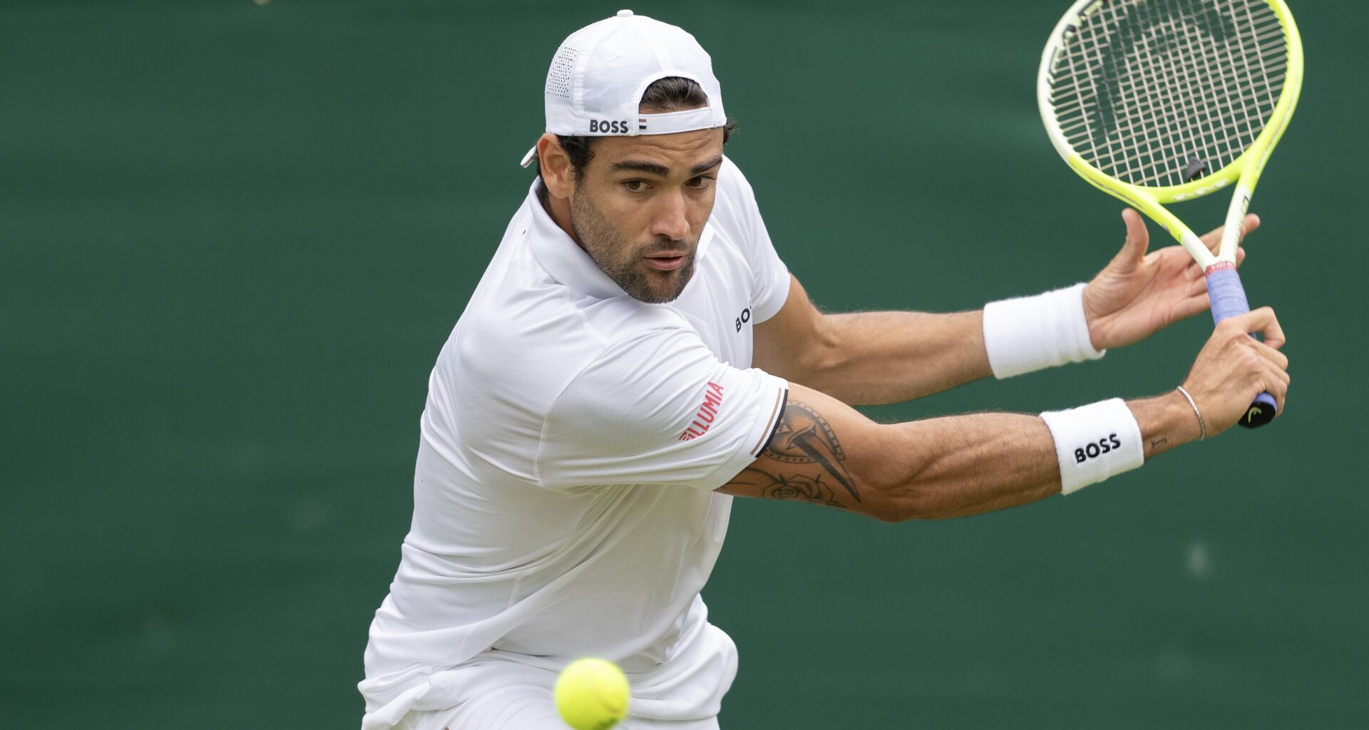 Matteo Berrettini looks to hit a backhand at Wimbledon in 2024.