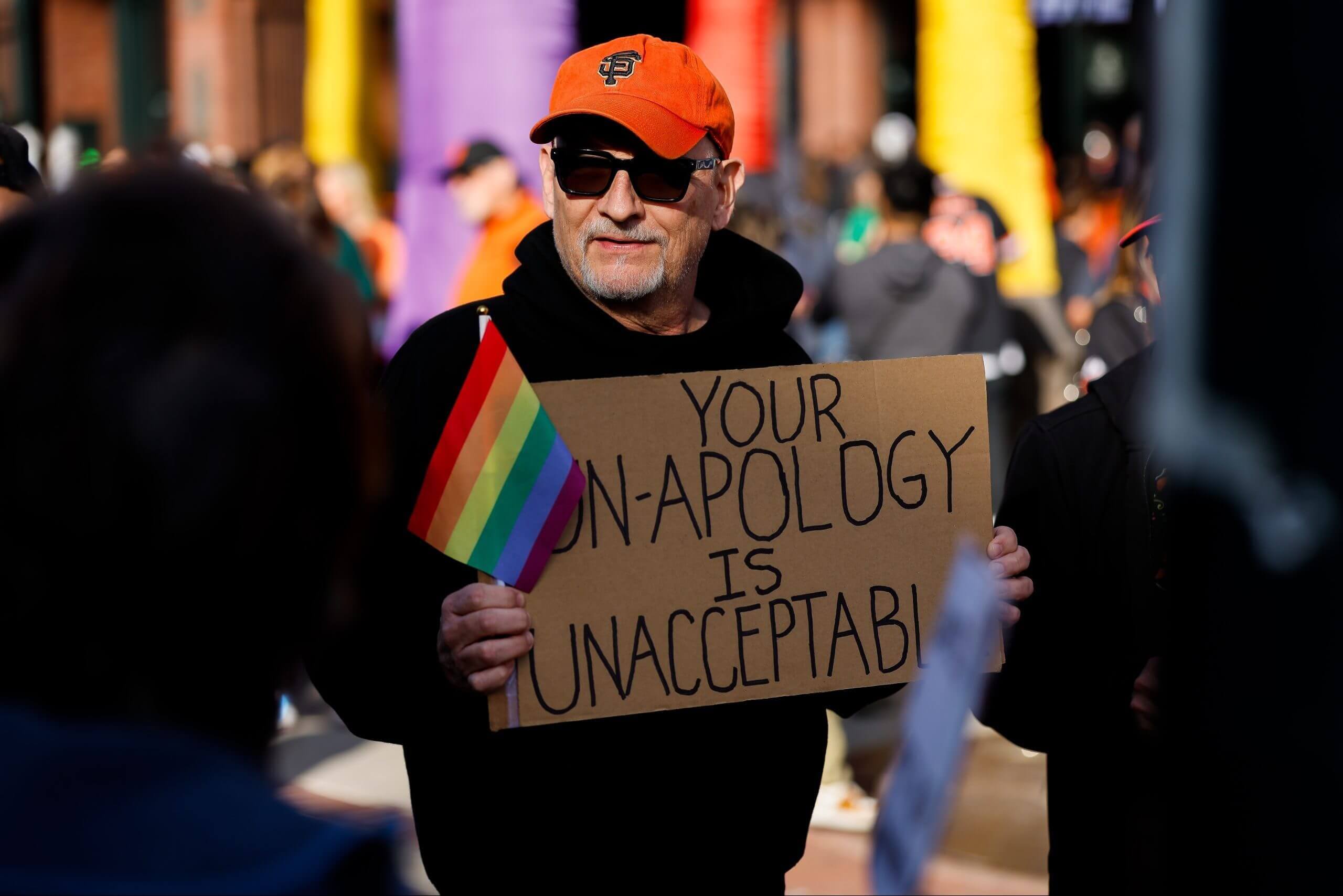 A protestor holds a sign in front a Giants-Athletics game in San Francisco