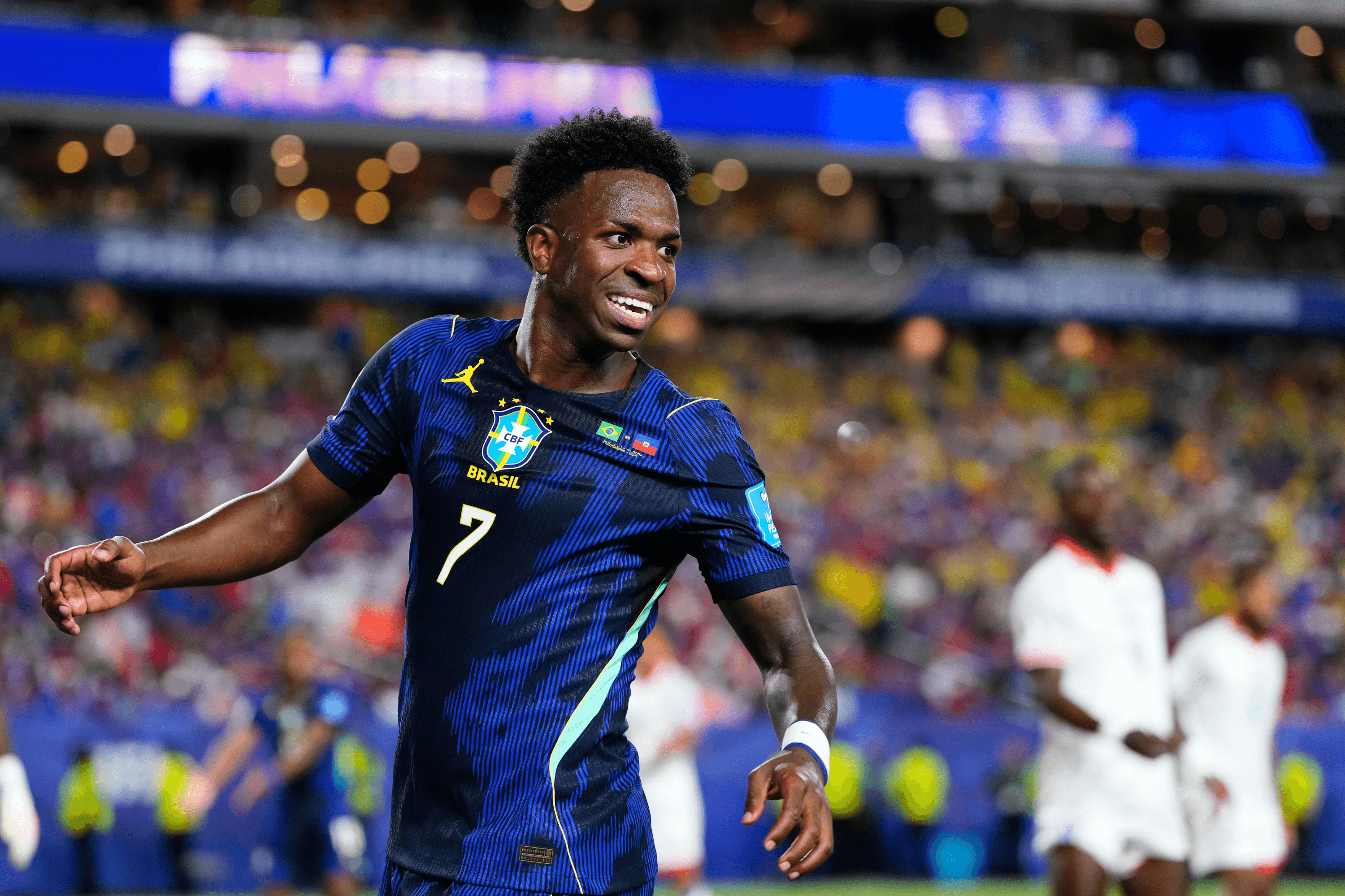 A footballer in a blue shirt smiles during a game