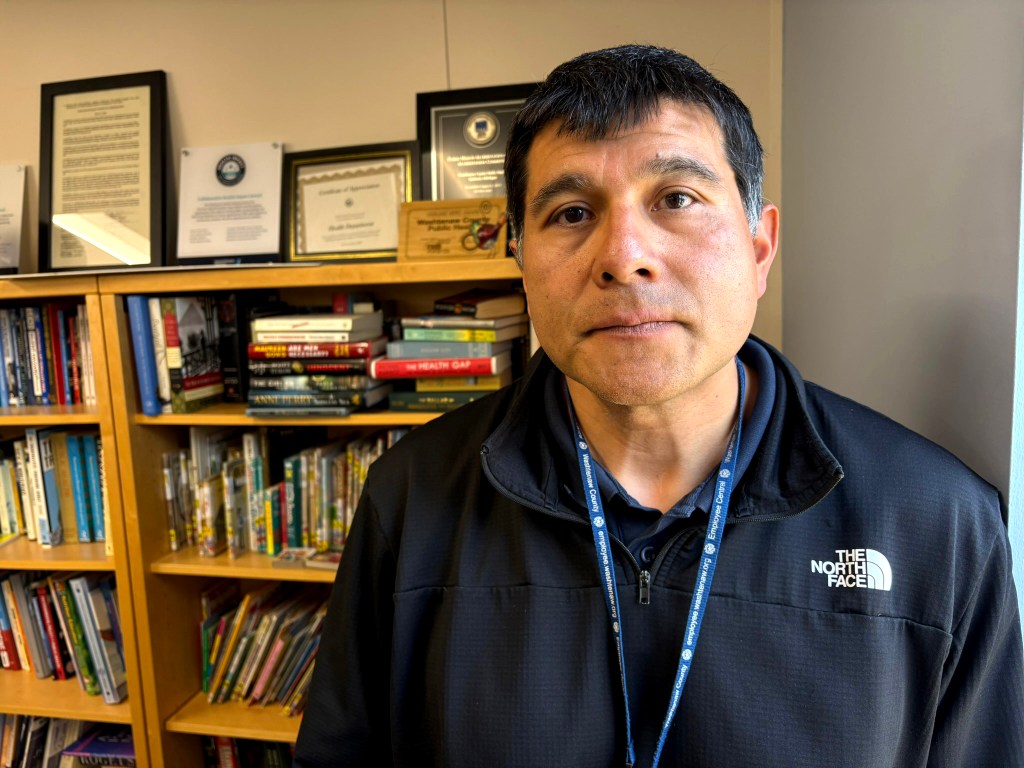 Juan Marquez is the medical director for Washtenaw and Livingston counties in Michigan. He says the in-person education sessions the state required for parents seeking vaccine waivers for their children became ineffective — and unsafe for staff. “Our nurses are just trying to do their job,” he says. “And you can imagine, to have somebody yell at you or just say not nice things to your face and sit through that for hours is demoralizing.” (Kate Wells/KFF Health News)