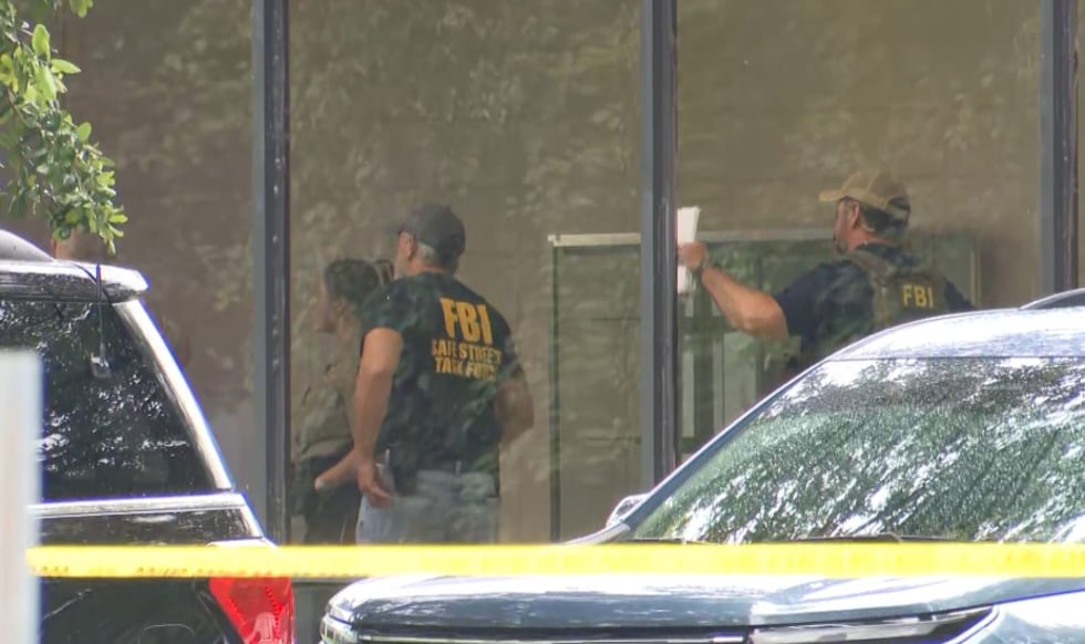 Law enforcement officials with the FBI and other agencies are seen at the Prichard Municipal...