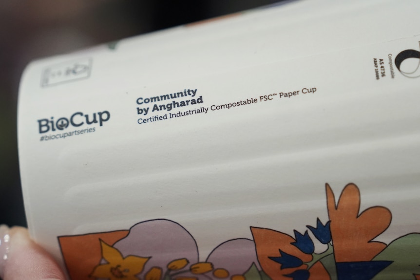 A paper coffee cup with the words "certified industrially compostable" printed on the side.