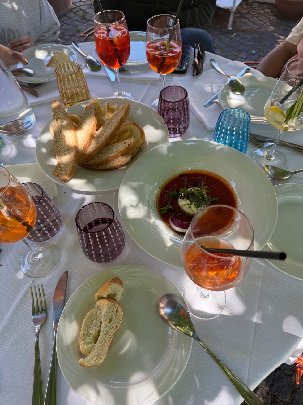 table with various plates of food and drink on