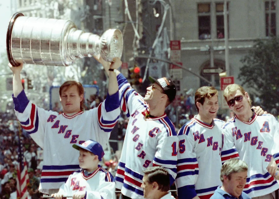 New York Rangers Mark Messier, Adam Graves, Mike Richter, Brian Leetch, Steve Larmer and Kevin Lowe take turns lifting the Stanley Cup on the lead float as over a million fans lined the Canyon of Heroes on Broadway during the Rangers ticker-tape parade June 17, 1994. A few days earlier the Rangers defeated the Vancouver Canucks 3-2 in Game 7 to win the cup.