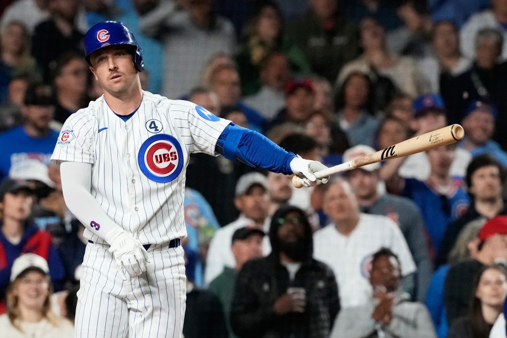Alex Bregman in a Chicago Cubs uniform, holding a baseball bat.