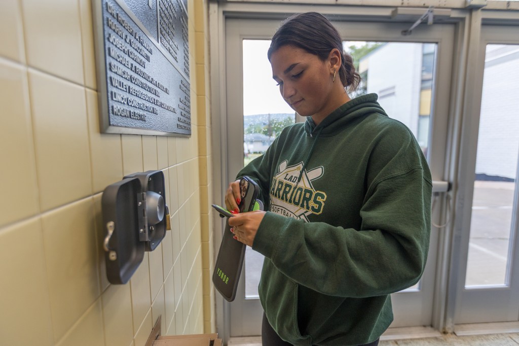 Ameriana Walker, senior student council vice president at Wyoming Area, demonstrates the function of the Yondr pouch.