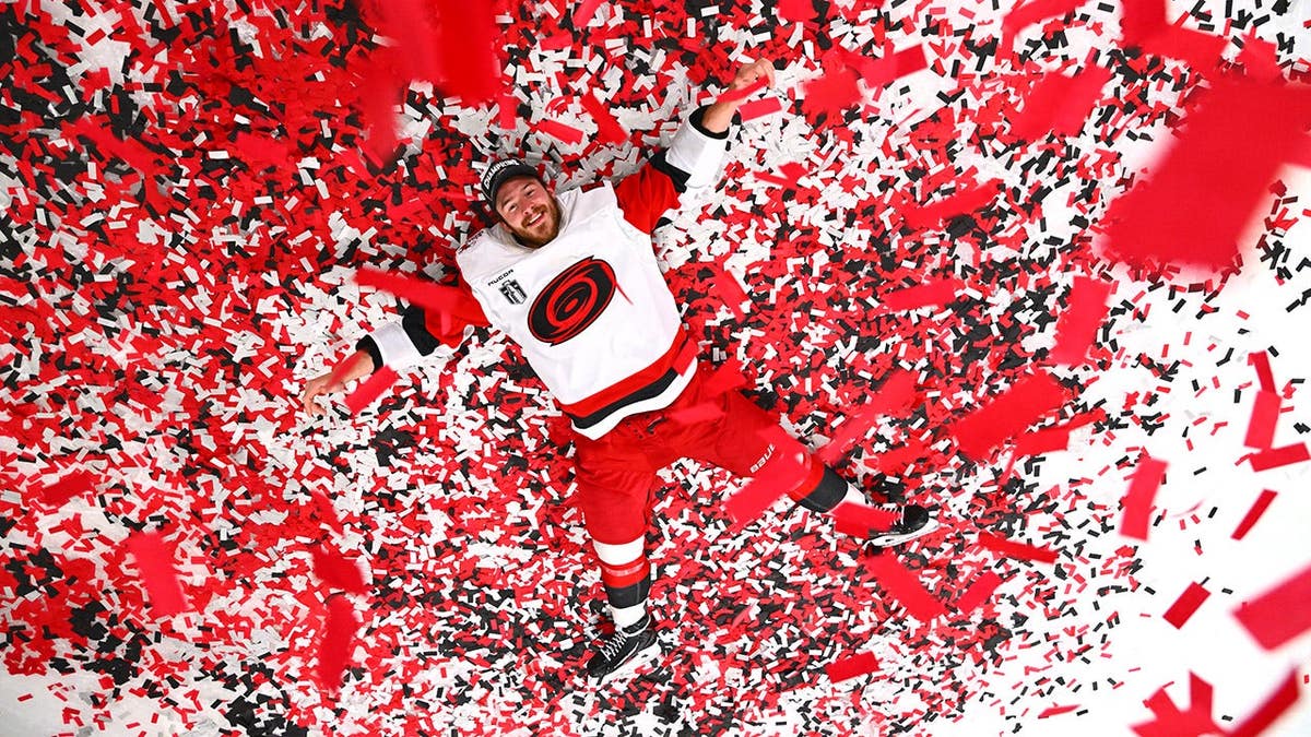 Andrei Svechnikov of the Carolina Hurricanes posing on ice with confetti