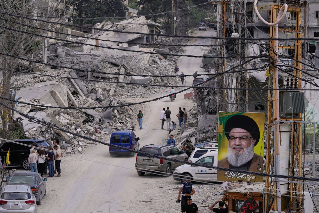 People who return to their village following the announcement of an initial ceasefire agreement between the United States and Iran, gather with journalists at a destroyed street in Beer al-Salassel, south Lebanon, on June 15.
