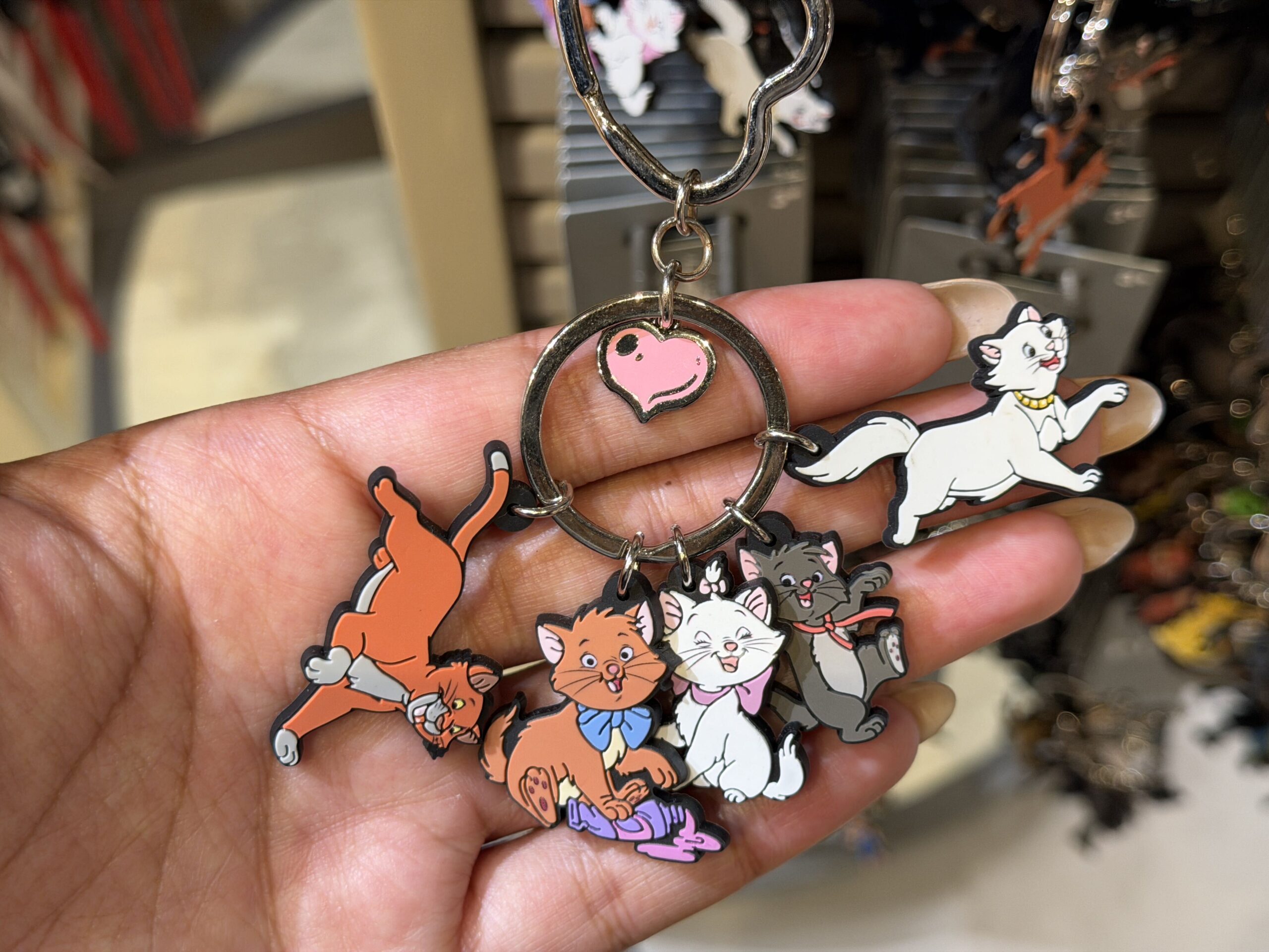 All five central characters from The Aristocats are included in this keyring set. There is Thomas O'Malley, Toulouse, Marie, Berlioz, and Duchess. A pink heart hangs in the center ring.
