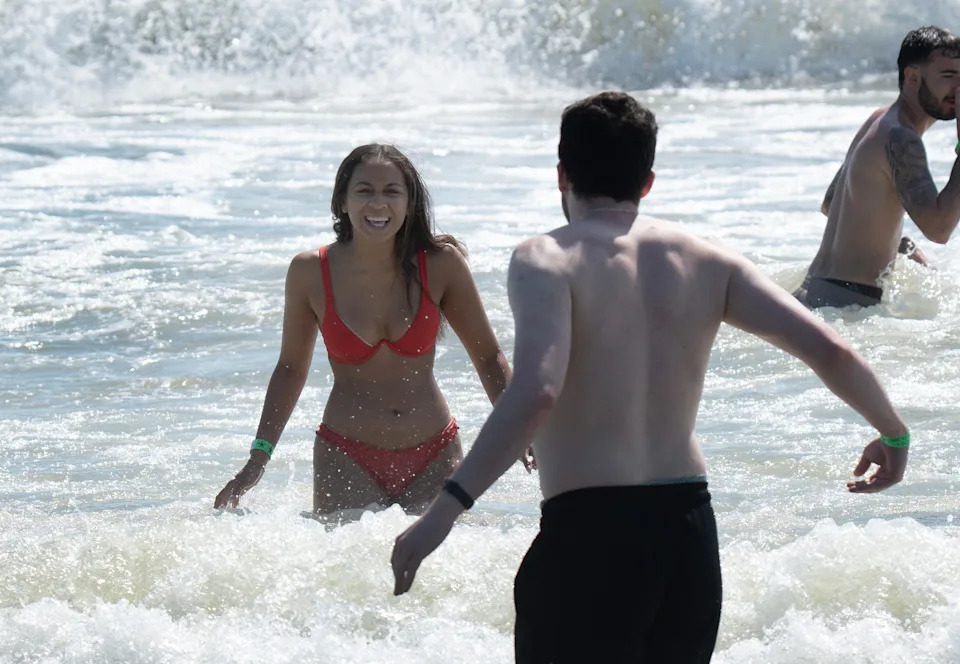 A woman coaxes a man to come deeper into the water as they swim in Asbury Park. Our Shore Towns: Asbury Park: From sunrise till past sunset.