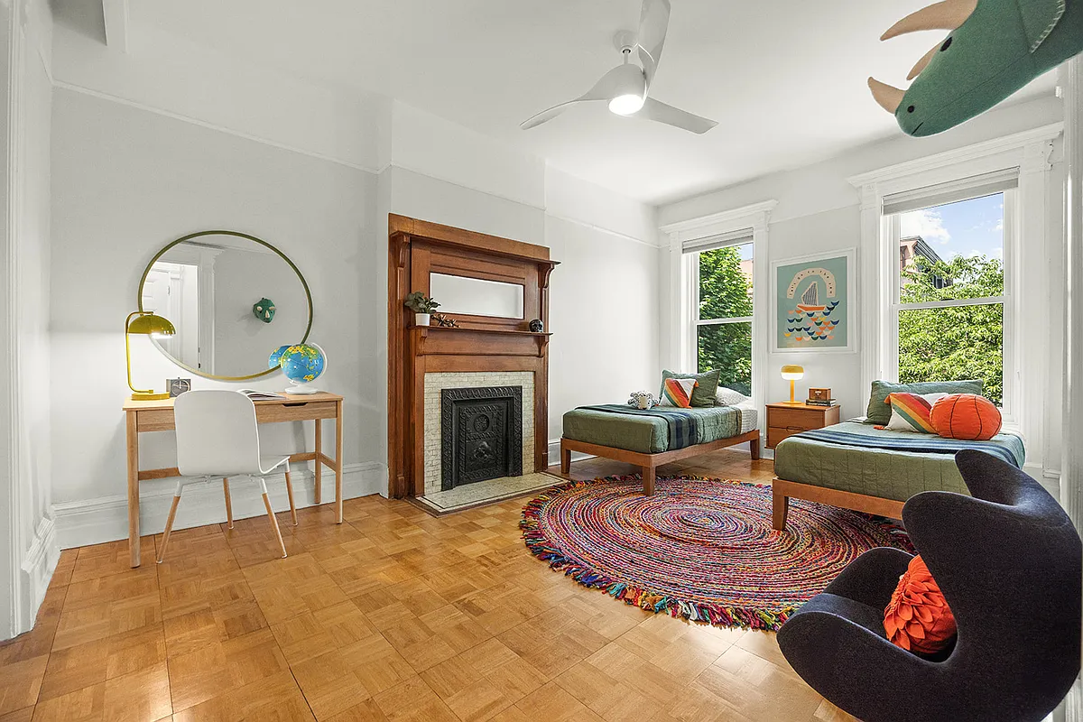 bedroom with white walls, wood mantel