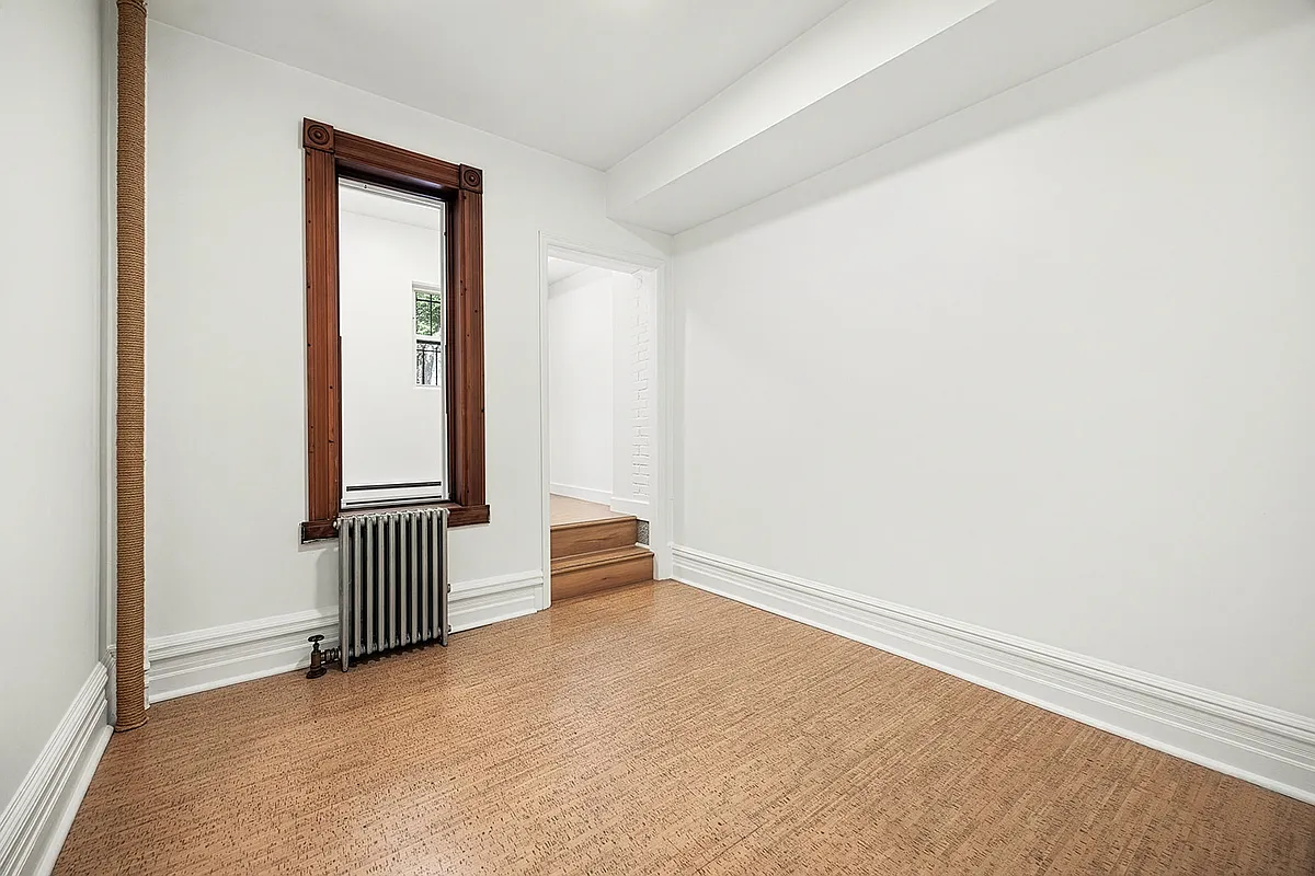 room with white walls and stairs up to a bedroom