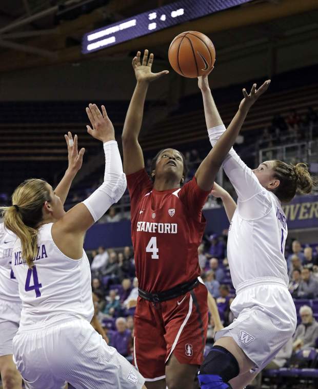 Stanford's Nadia Fingall, center, reaches for a rebound between Washington's Amber Melgoza, left, and Hannah Johnson during the first half of an NCAA college basketball game Friday, Feb. 23, 2018, in Seattle. (AP Photo/Elaine Thompson)