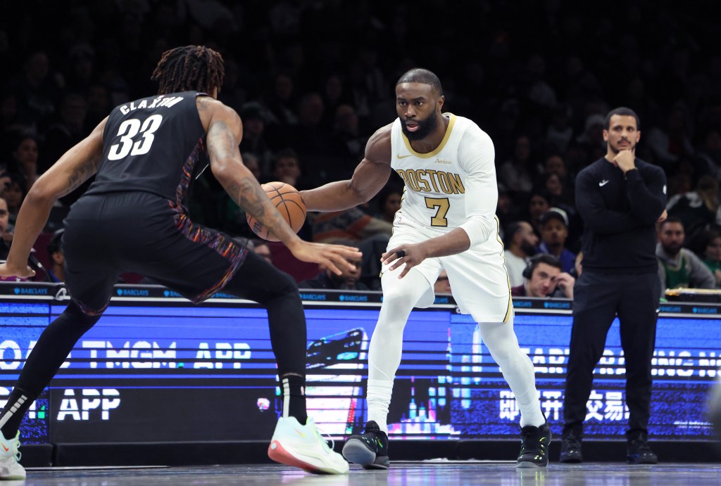 Boston Celtics guard Jaylen Brown dribbling the ball while guarded by Brooklyn Nets center Nic Claxton.