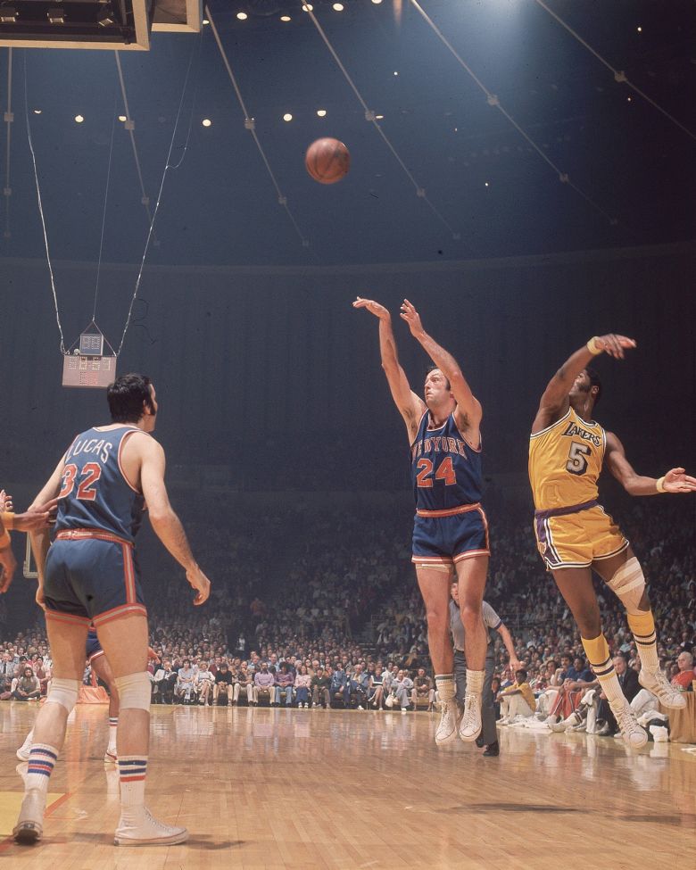 Former New York Knicks forward Bill Bradley #24 takes a shot around Los Angeles Lakers Jim McMillian #5 in Inglewood, California during the 1973 NBA Finals.