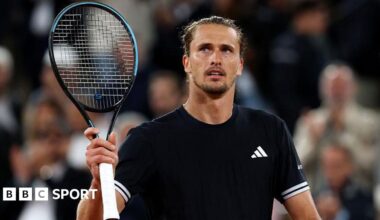 Alexander Zverev holds up a tennis racquet