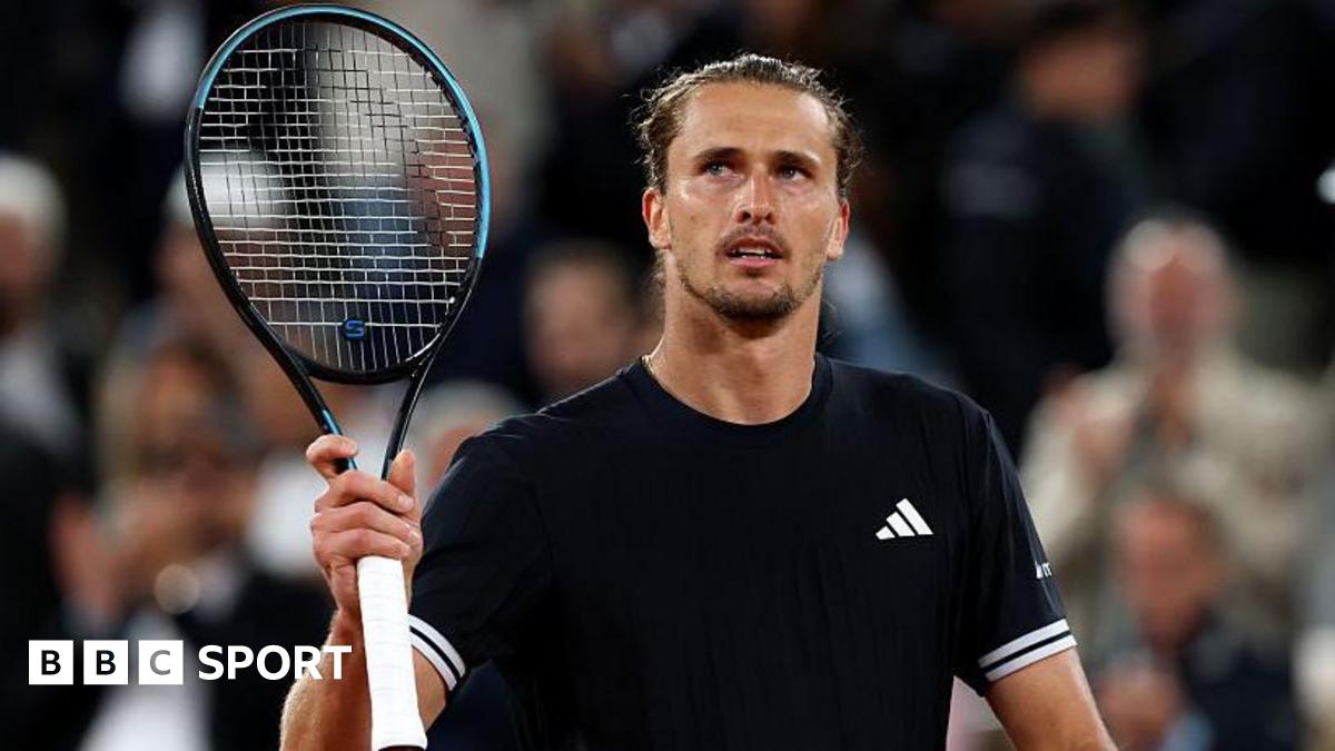 Alexander Zverev holds up a tennis racquet
