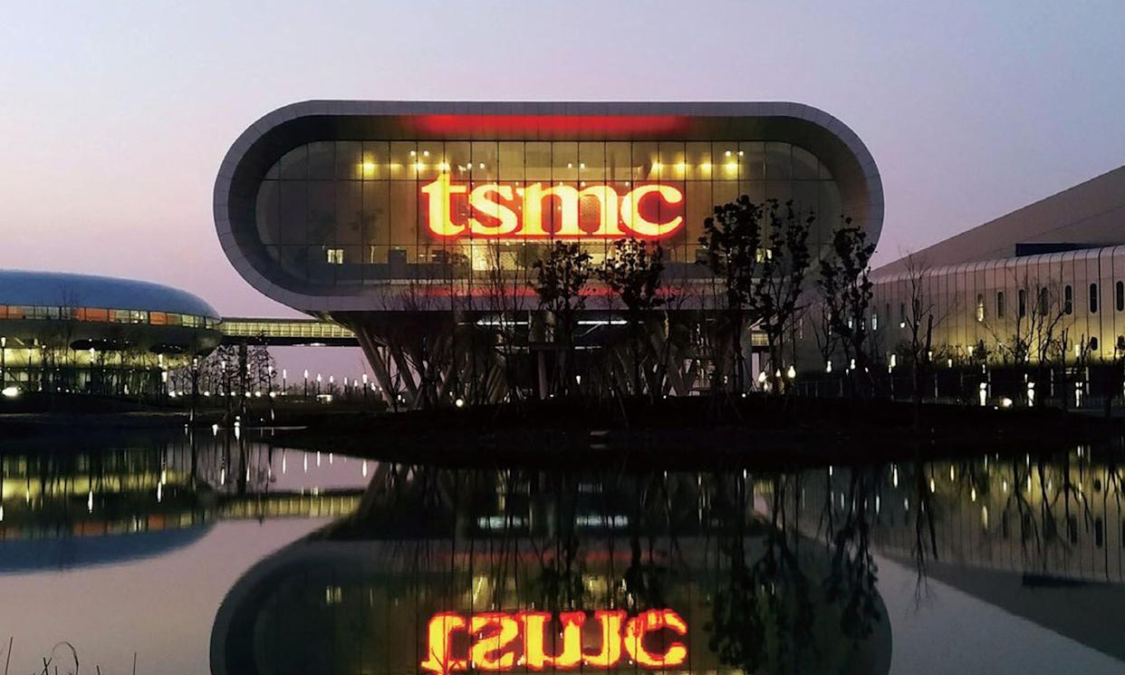 TSMC logo displayed in red on a company building during evening time.