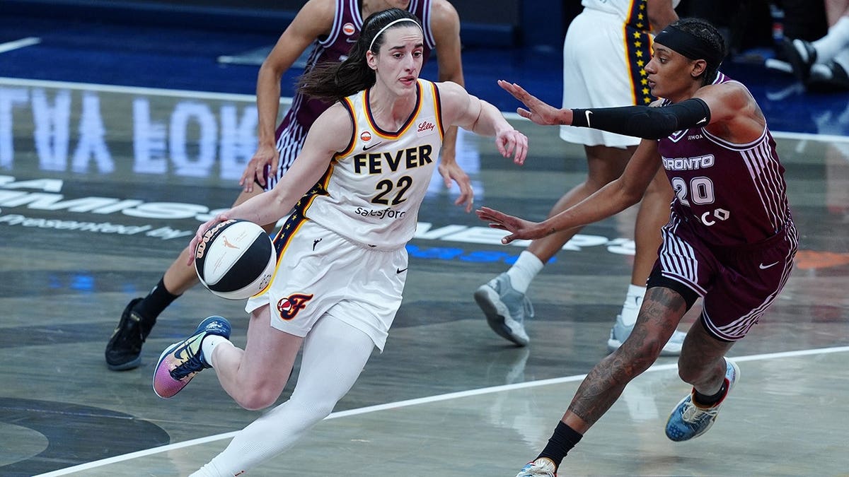 Indiana Fever guard Caitlin Clark drives to the basket against Toronto Tempo guard Brittney Sykes at Gainbridge Fieldhouse