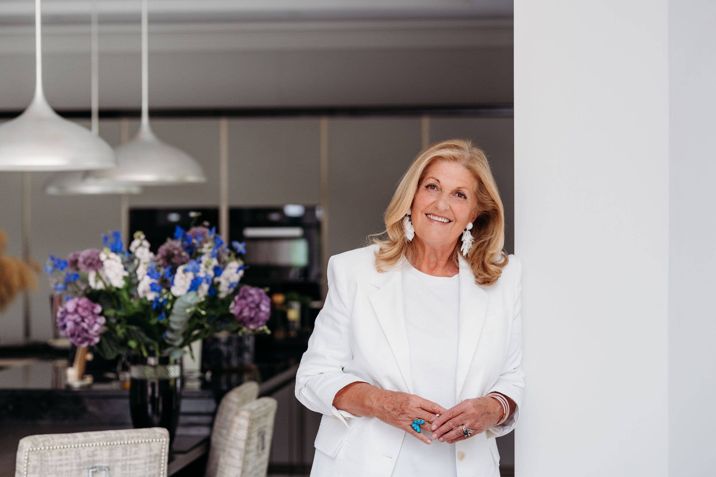 woman smiling in white in her kitchen