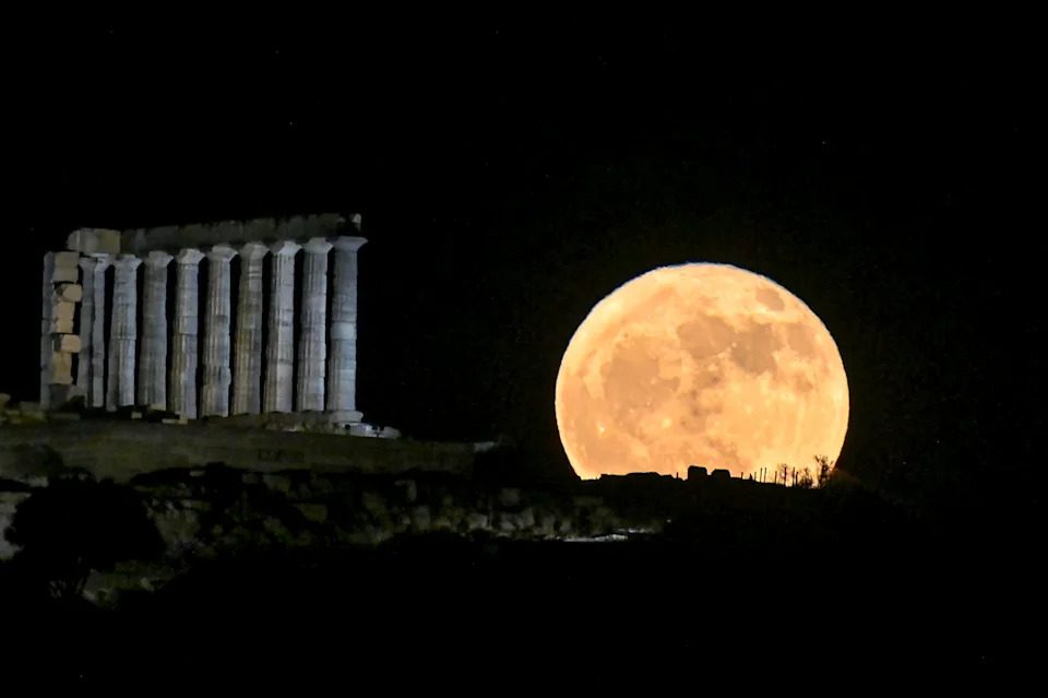 A full moon rises over the ancient Greek Temple of Poseidon.