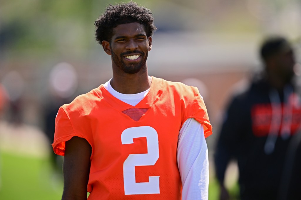 Cleveland Browns quarterback Shedeur Sanders smiles on the field after practice.